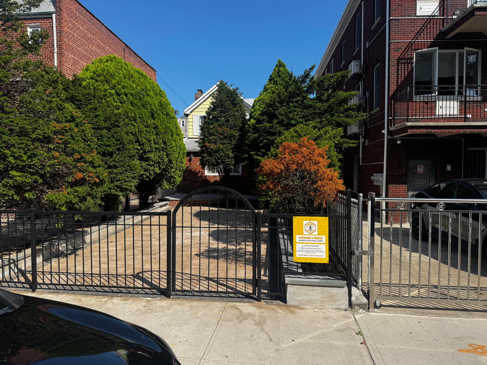 New paver driveway and black aluminum fence with arched gate — photo 2